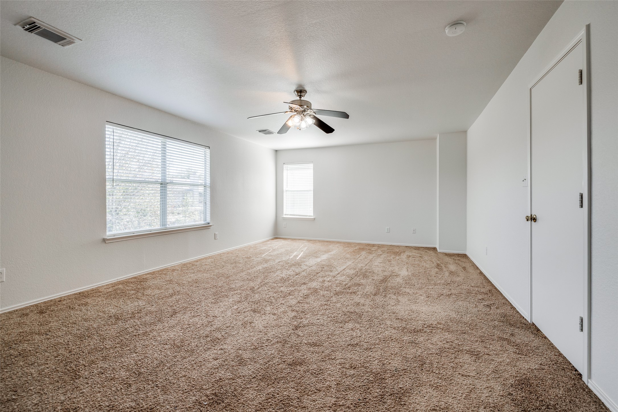 5750 Roehampton Court Houston, TX 77084 - Photo 16 of 25 an empty room with windows and ceiling fan