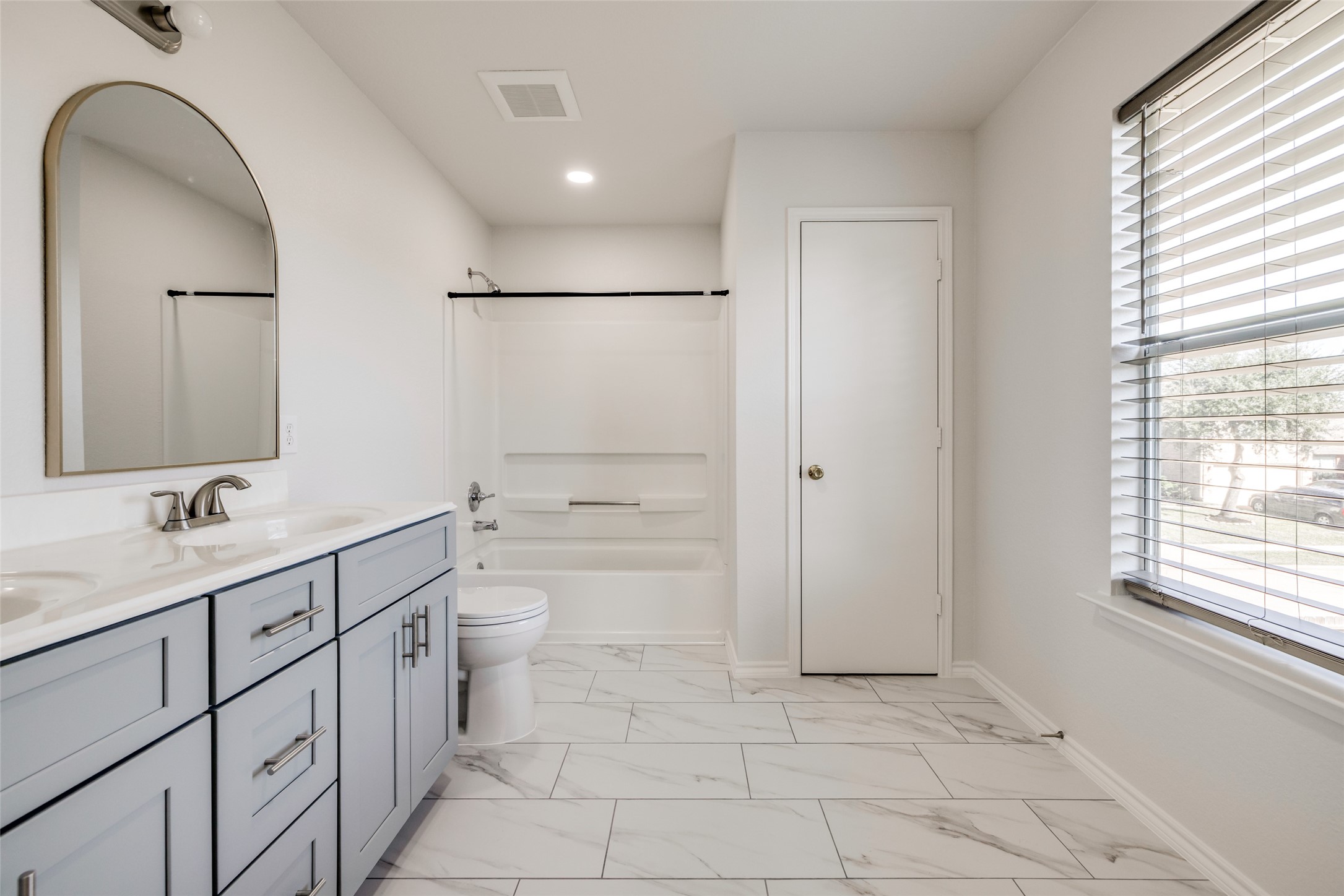 5750 Roehampton Court Houston, TX 77084 - Photo 17 of 25 a bathroom with a double vanity sink a toilet and a mirror