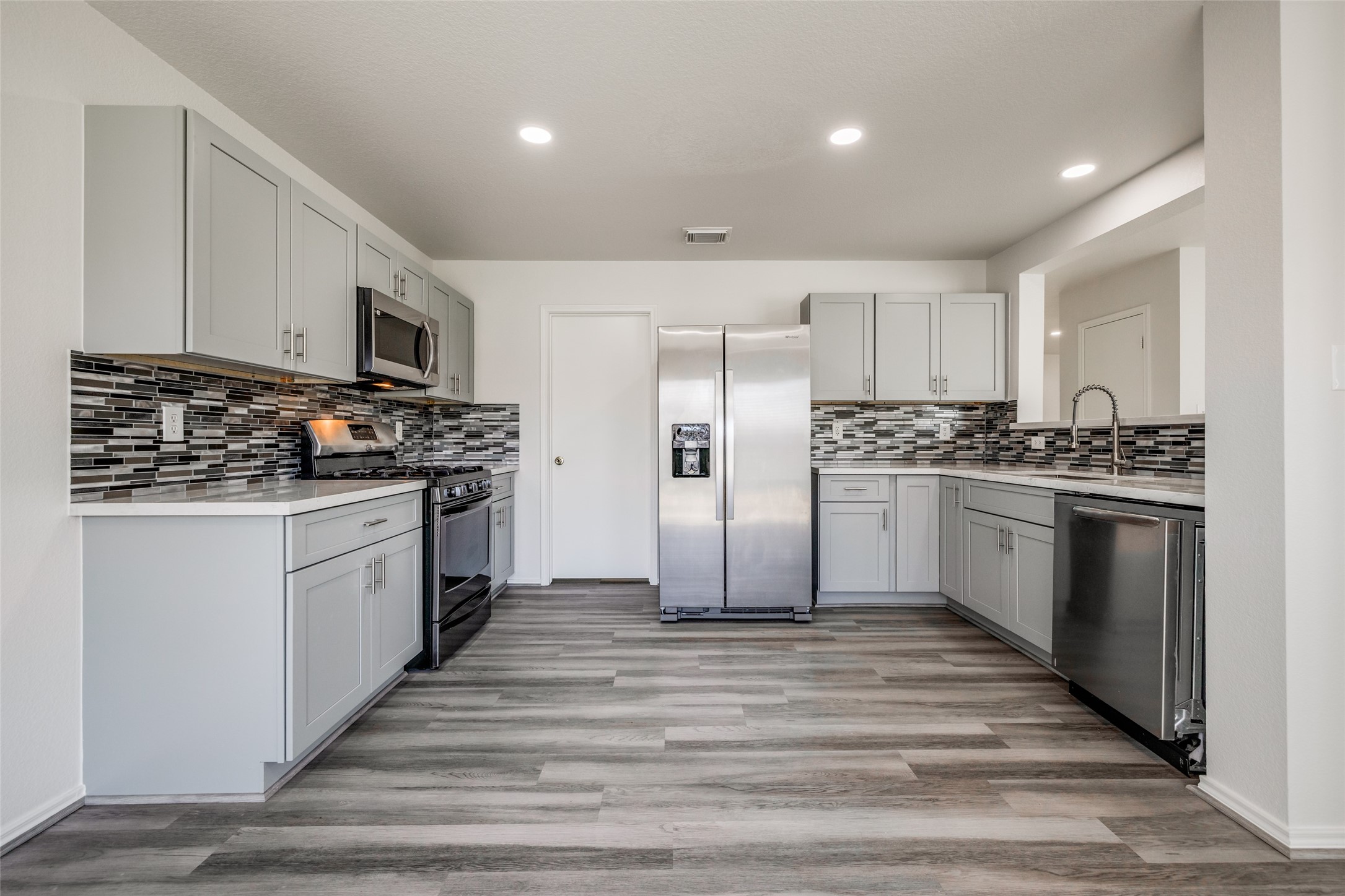 5750 Roehampton Court Houston, TX 77084 - Photo 2 of 25 a kitchen with stainless steel appliances kitchen island granite countertop a stove a sink and a refrigerator