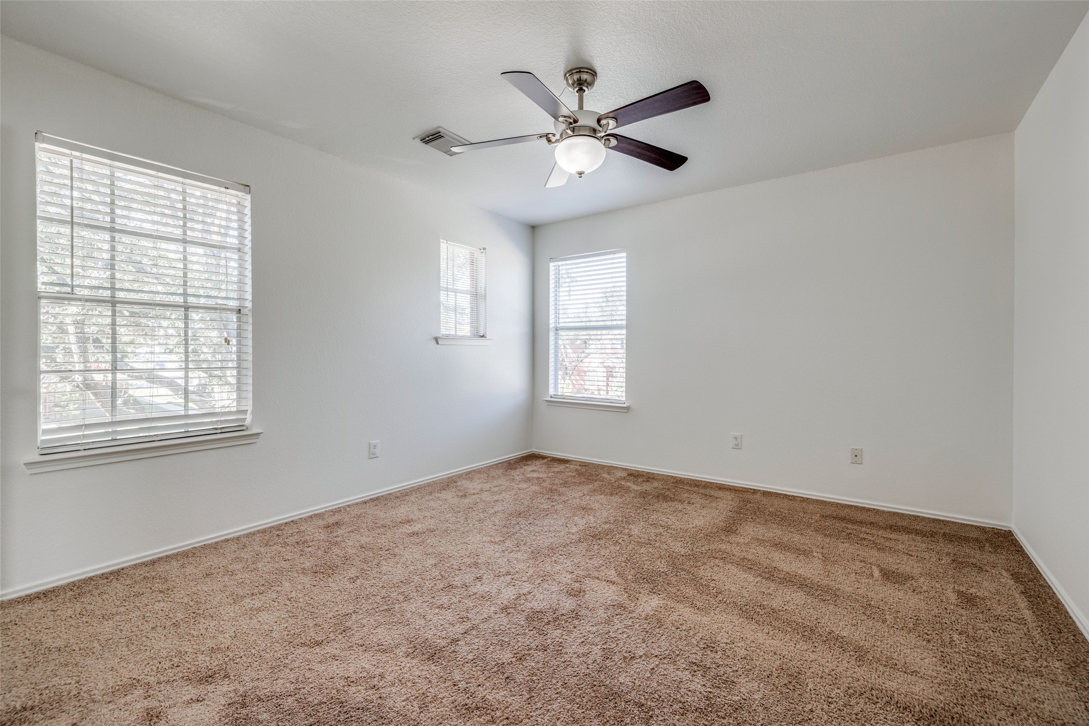 5750 Roehampton Court Houston, TX 77084 - Photo 22 of 25 an empty room with windows and fan