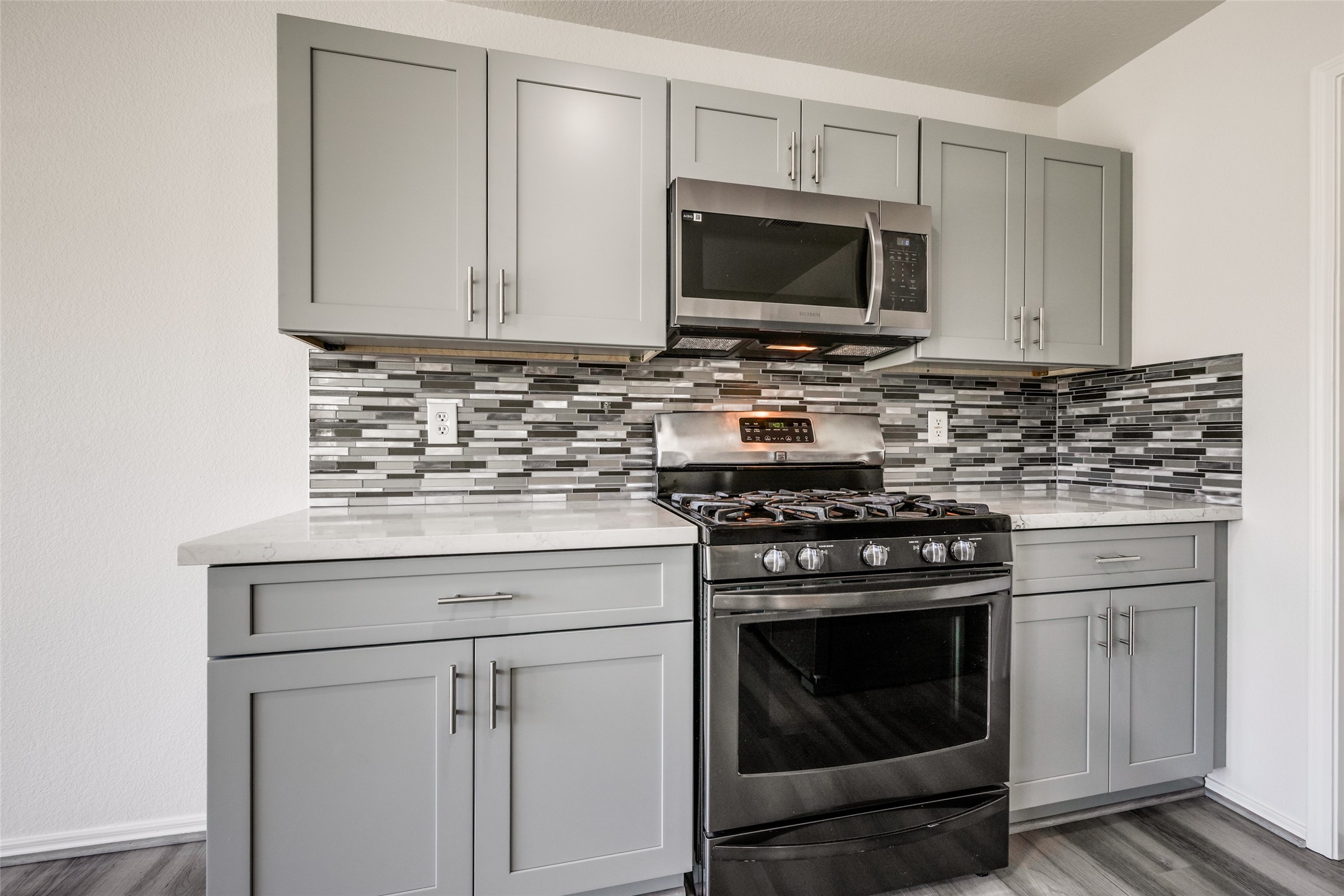 5750 Roehampton Court Houston, TX 77084 - Photo 4 of 25 a kitchen with granite countertop a stove top oven microwave and cabinets