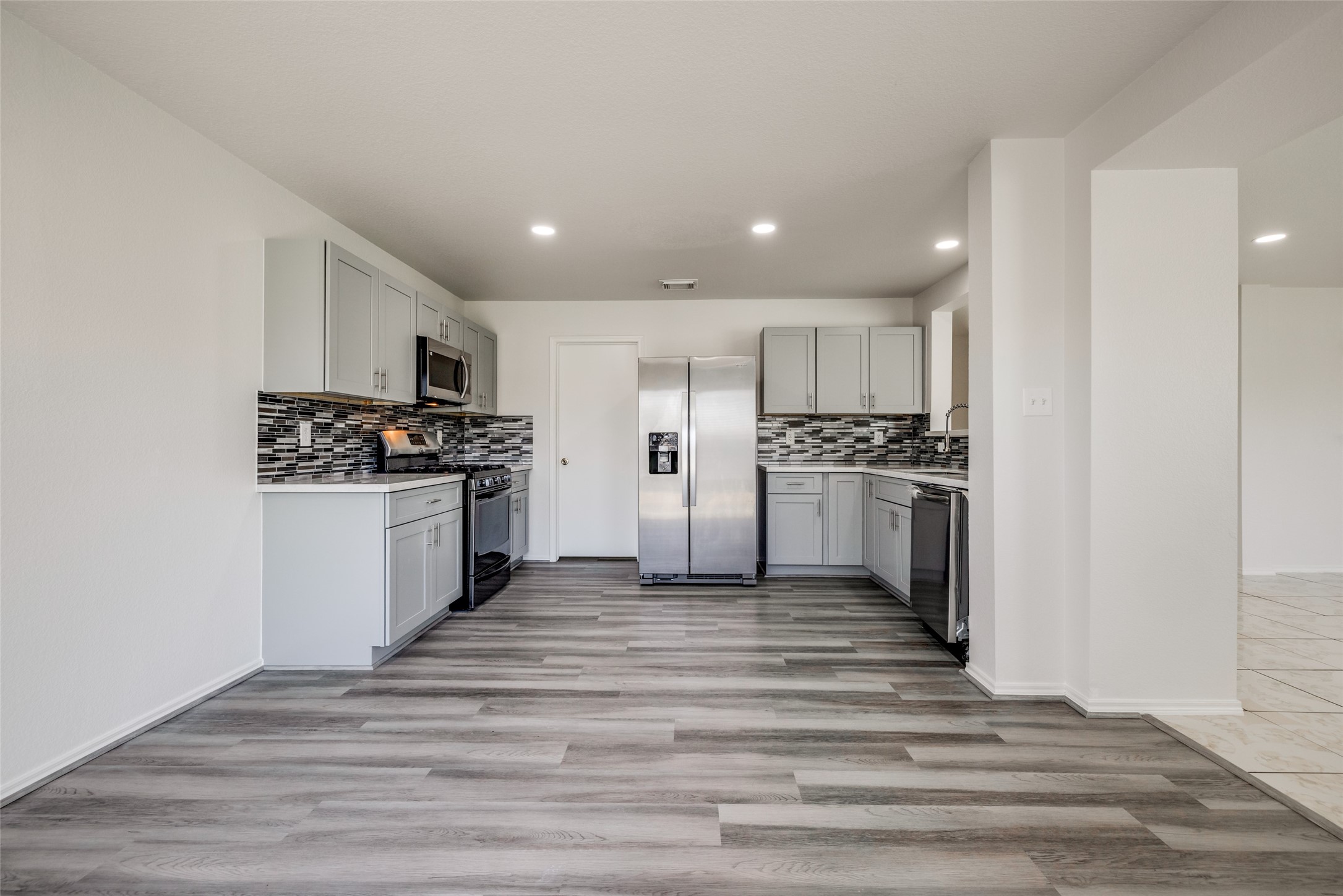 5750 Roehampton Court Houston, TX 77084 - Photo 5 of 25 a kitchen with stainless steel appliances kitchen island a refrigerator and a stove top oven
