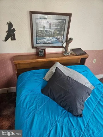 a bedroom with a bed and a painting on the wall