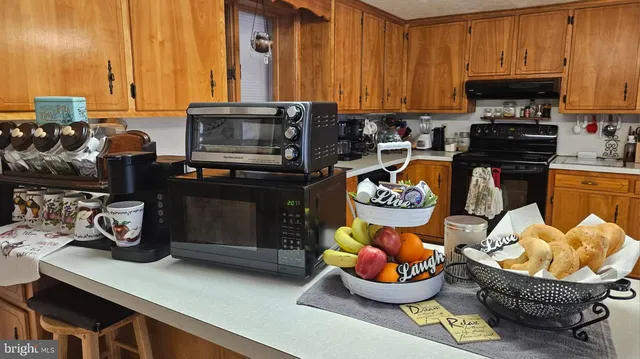 a kitchen with granite countertop a stove a sink and a microwave