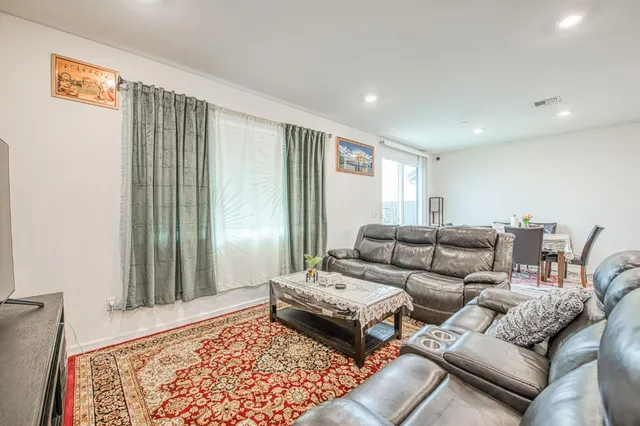a living room with furniture and a view of kitchen