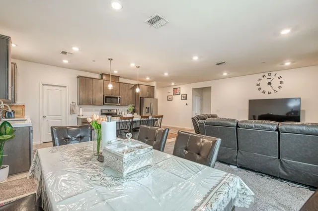 a kitchen with a table chairs refrigerator and microwave