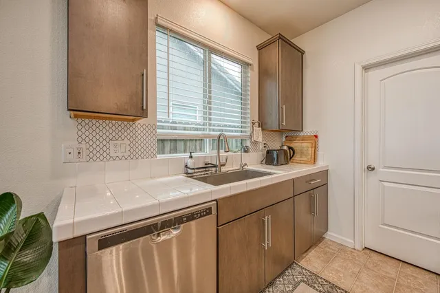 a large kitchen with stainless steel appliances granite countertop a lot of counter space and a sink