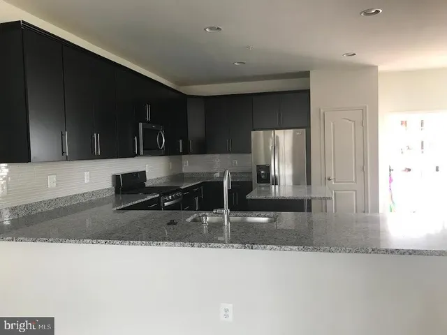 a kitchen with stainless steel appliances granite countertop a sink and a stove top oven