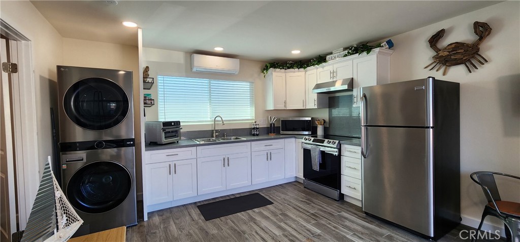 a kitchen with stainless steel appliances granite countertop a refrigerator a washer and dryer