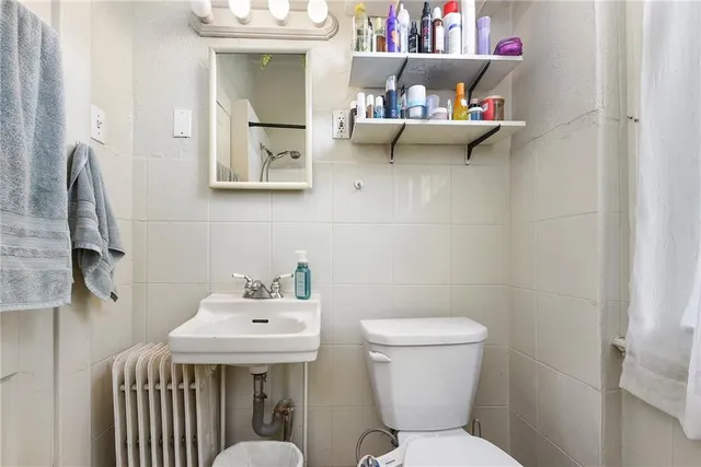 a bathroom with a sink mirror and toilet