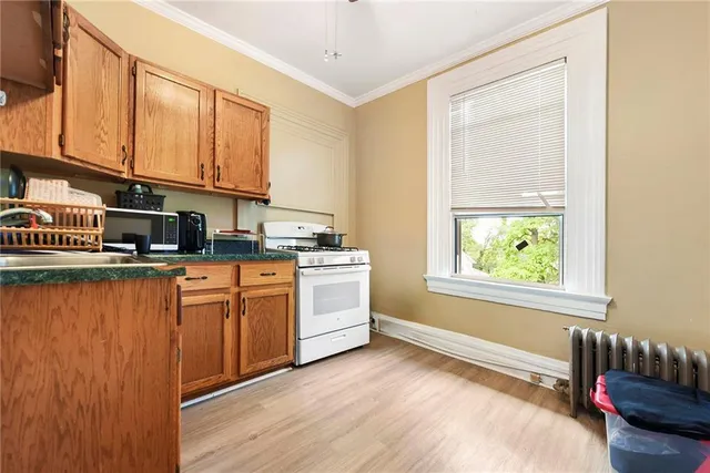 a kitchen with stainless steel appliances granite countertop a stove a sink and a refrigerator with wooden floors