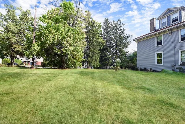a view of a house with backyard and tree