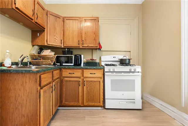 a kitchen with stainless steel appliances granite countertop a stove a sink and a microwave