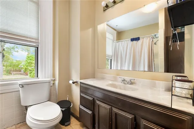 a bathroom with a sink a toilet a mirror and a window