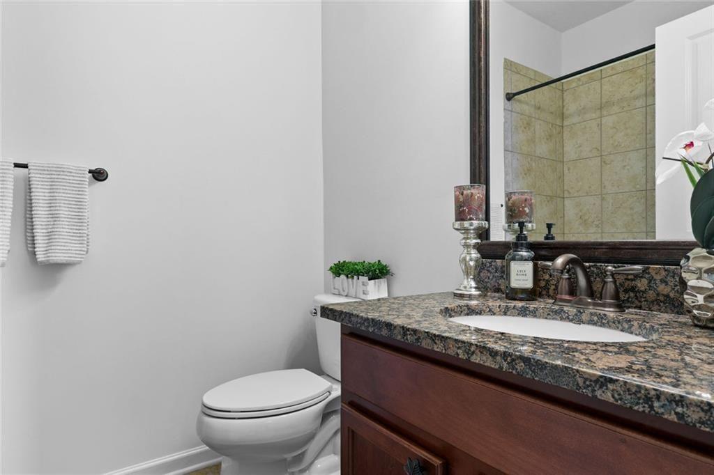 3935 Silver Springs Road Cumming, GA 30041 - Photo 17 of 37 a bathroom with a granite countertop sink a toilet and a mirror