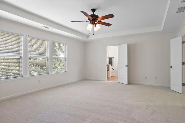an empty room with a ceiling fan and window