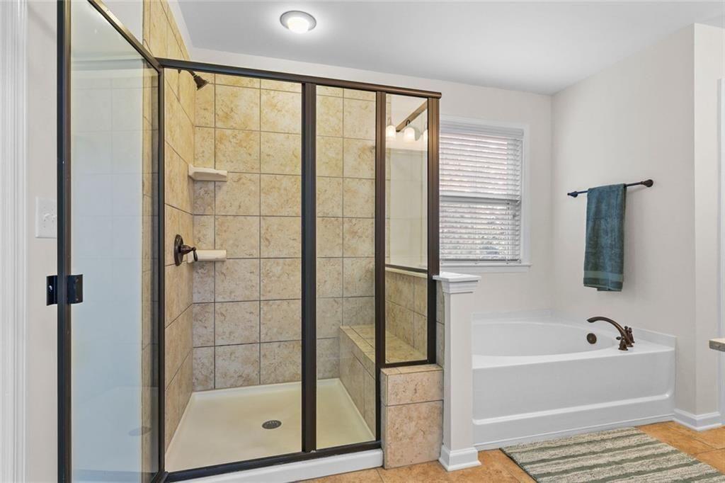 3935 Silver Springs Road Cumming, GA 30041 - Photo 21 of 37 a bathroom with a bathtub and a shower