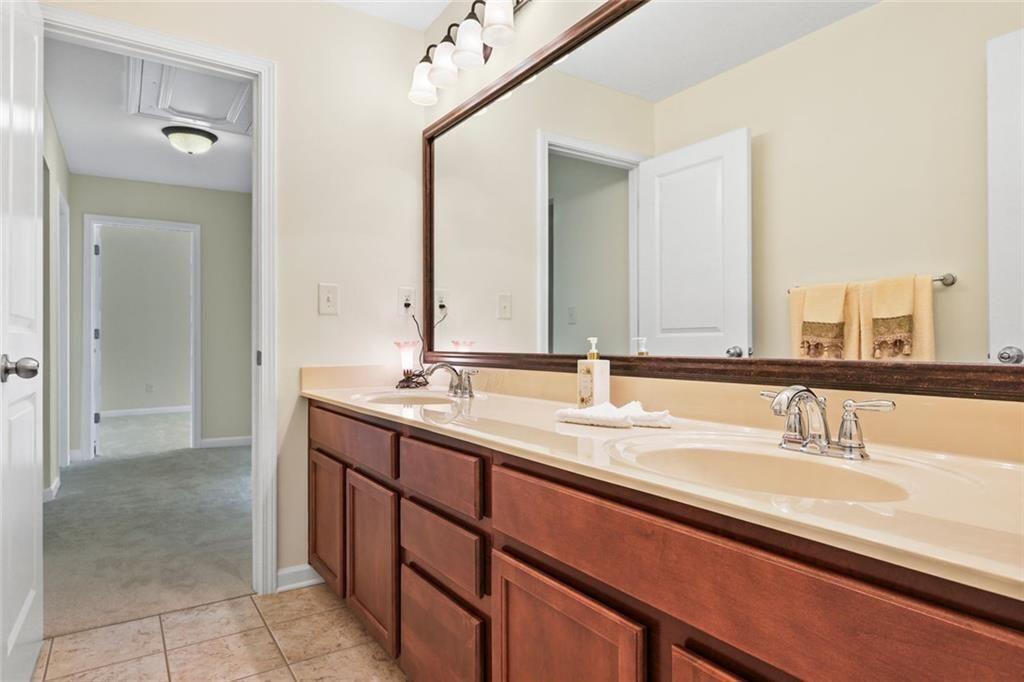 3935 Silver Springs Road Cumming, GA 30041 - Photo 28 of 37 a bathroom with a double vanity sink and a mirror