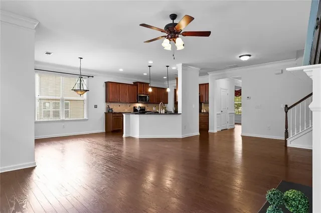 an open kitchen with stainless steel appliances kitchen island a chandelier and wooden floor
