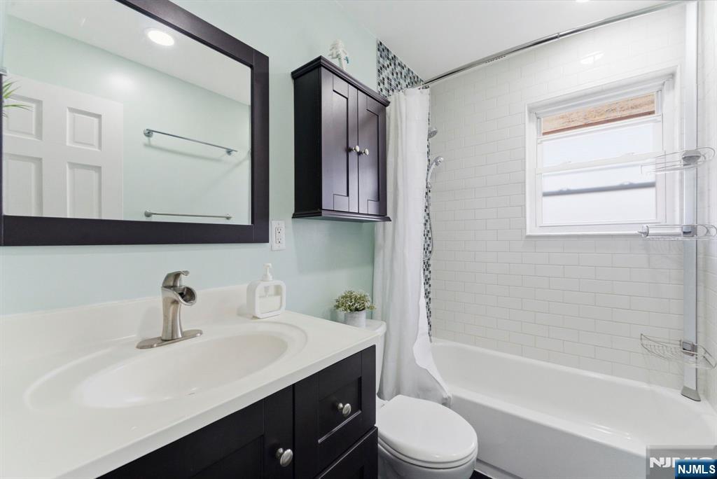 50-56 High Street, Unit 2 Passaic, NJ 07055 - Photo 16 of 30 a bathroom with a sink a toilet a mirror and shower