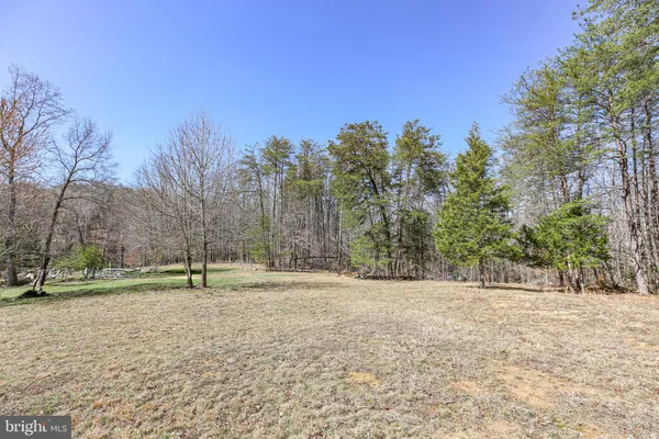 a big yard with lots of green space and mountain view in back