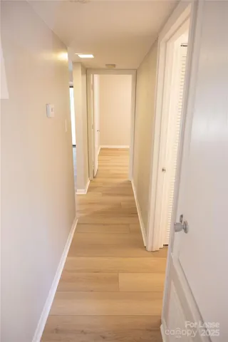 a view of a hallway with wooden floor and staircase