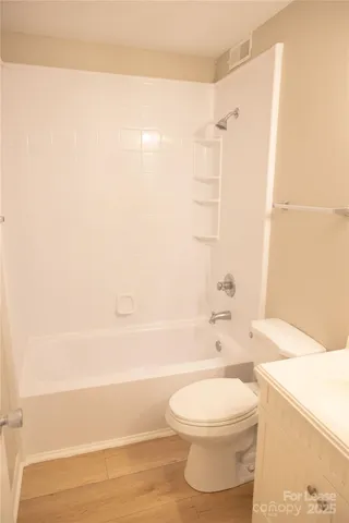 a bathroom with a white toilet and a bath tub