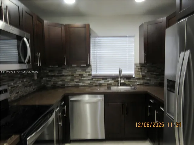 a kitchen with granite countertop a sink stove and refrigerator