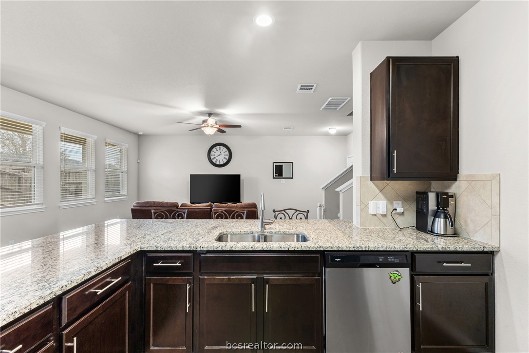984 Crossing Drive Bryan, TX 77803 - Photo 11 of 29 a kitchen with granite countertop a sink and cabinets
