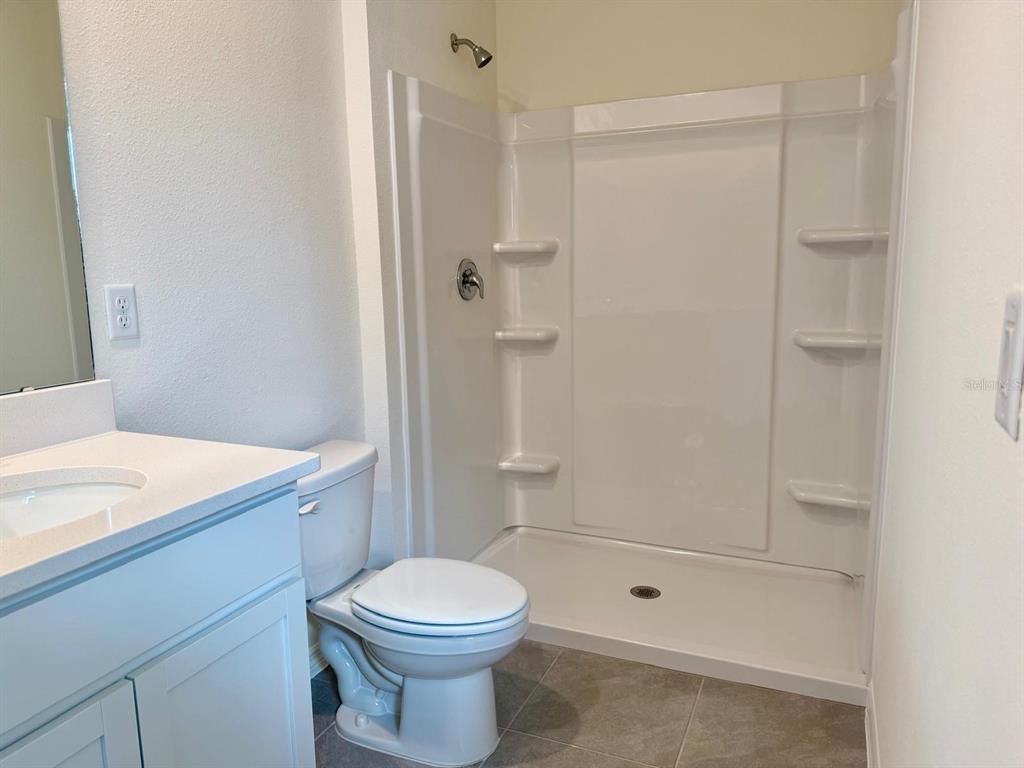 1642 Rock Elm Road Davenport, FL 33837 - Photo 18 of 27 a bathroom with a granite countertop sink a toilet and shower