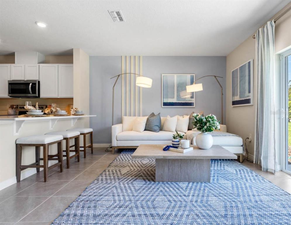 1642 Rock Elm Road Davenport, FL 33837 - Photo 2 of 27 a living room with furniture a rug and kitchen view