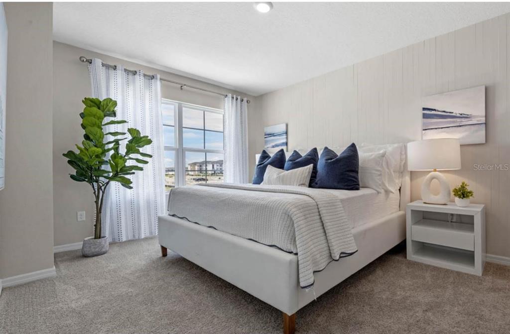 1642 Rock Elm Road Davenport, FL 33837 - Photo 21 of 27 a bedroom with a bed and a potted plant