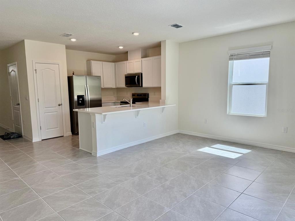 1642 Rock Elm Road Davenport, FL 33837 - Photo 8 of 27 a kitchen with stainless steel appliances a refrigerator and a stove top oven