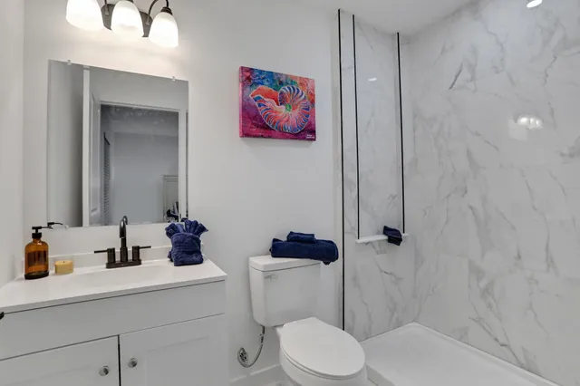 a bathroom with a sink vanity mirror and toilet