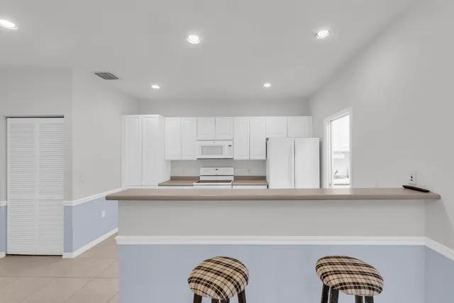 a kitchen with stainless steel appliances granite countertop white cabinets and window