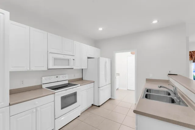 a kitchen with white cabinets and white appliances