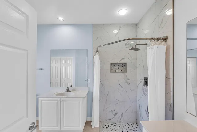 a bathroom with a shower sink and mirror