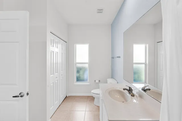 a bathroom with a sink vanity granite tub and a mirror