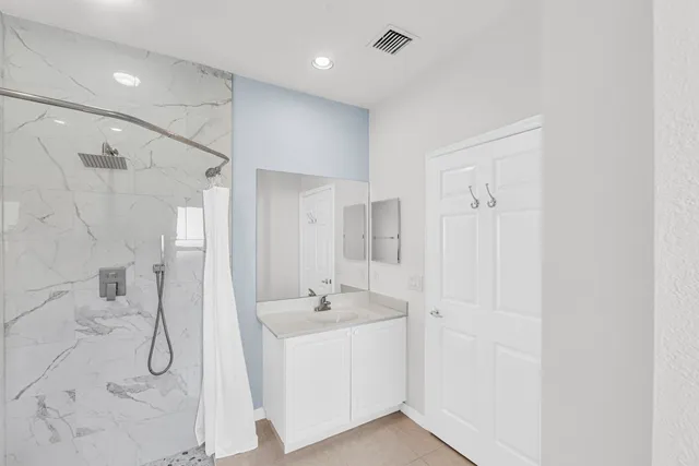 a bathroom with a double vanity sink a mirror and shower