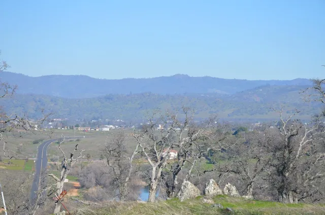 a view of a dry yard with mountains in the background