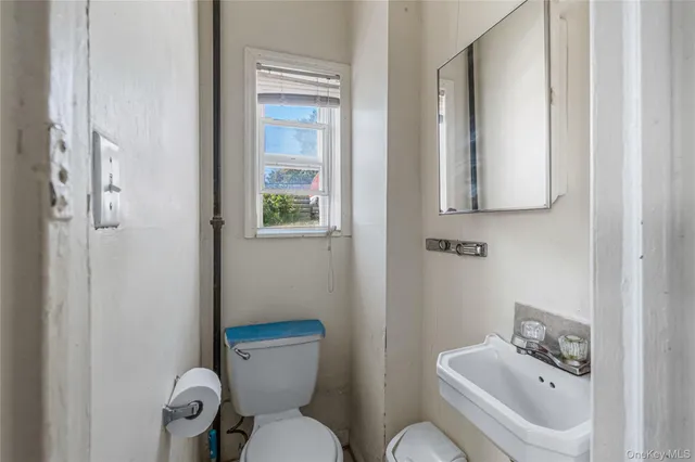 a bathroom with a toilet sink and mirror