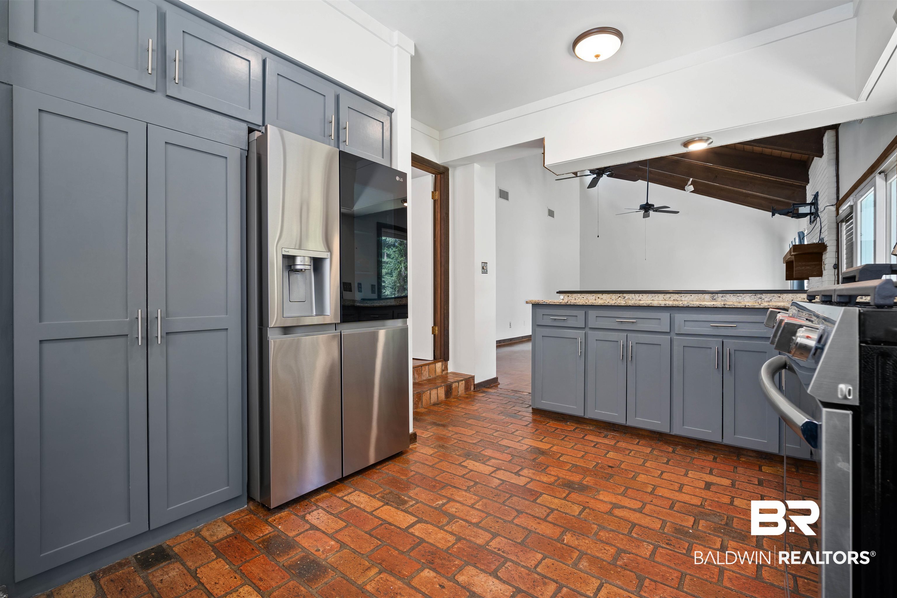 7912 Yorkhaven Road Mobile, AL 36695 - Photo 11 of 41 Kitchen with gray cabinets, stainless steel appliances, brick floors, ceiling fan, and vaulted ceiling