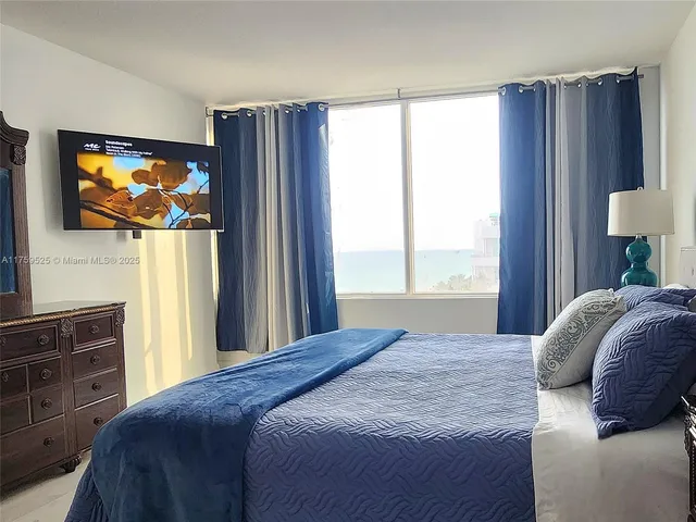 a bedroom with a bed and a flat screen tv