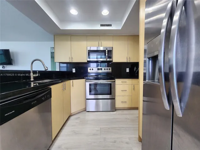 a kitchen with stainless steel appliances and a counter top space