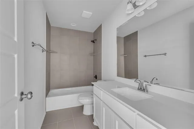 a bathroom with a granite countertop sink a toilet and shower