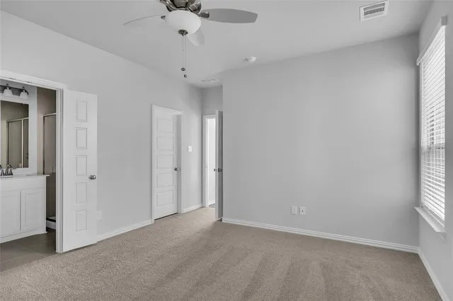an empty room with a window and a ceiling fan
