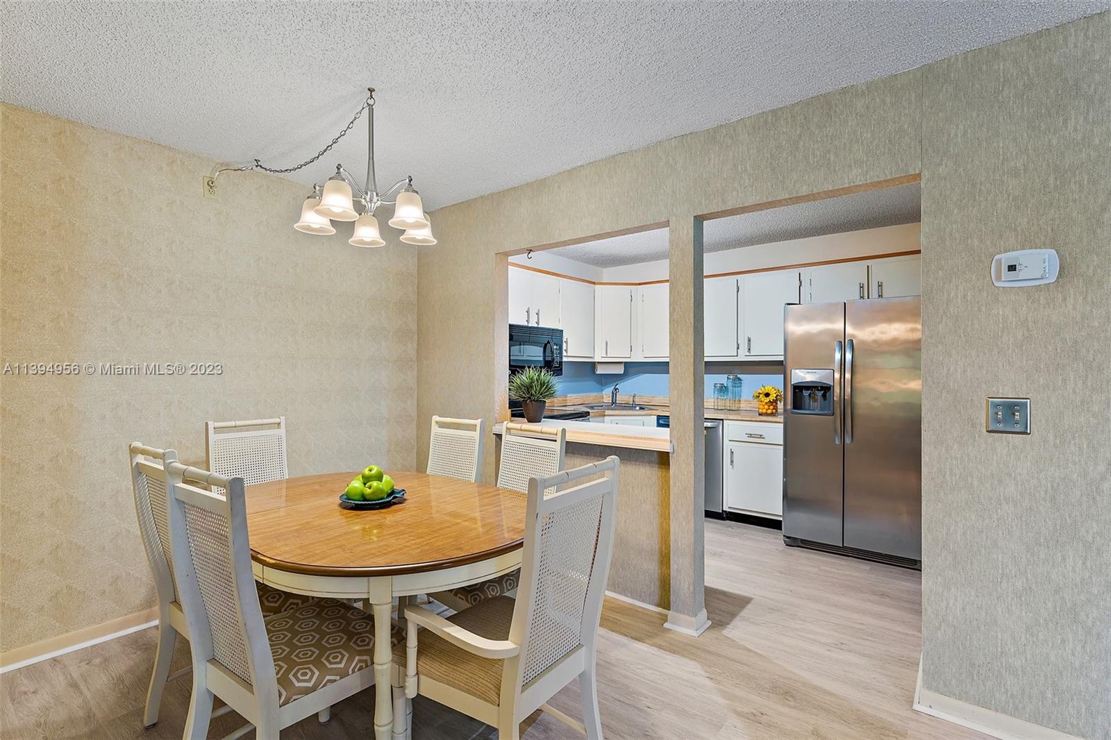 307 Pine Ridge Circle, Unit D2 Greenacres, FL 33463 - Photo 12 of 41 a kitchen with a dining table chairs and refrigerator