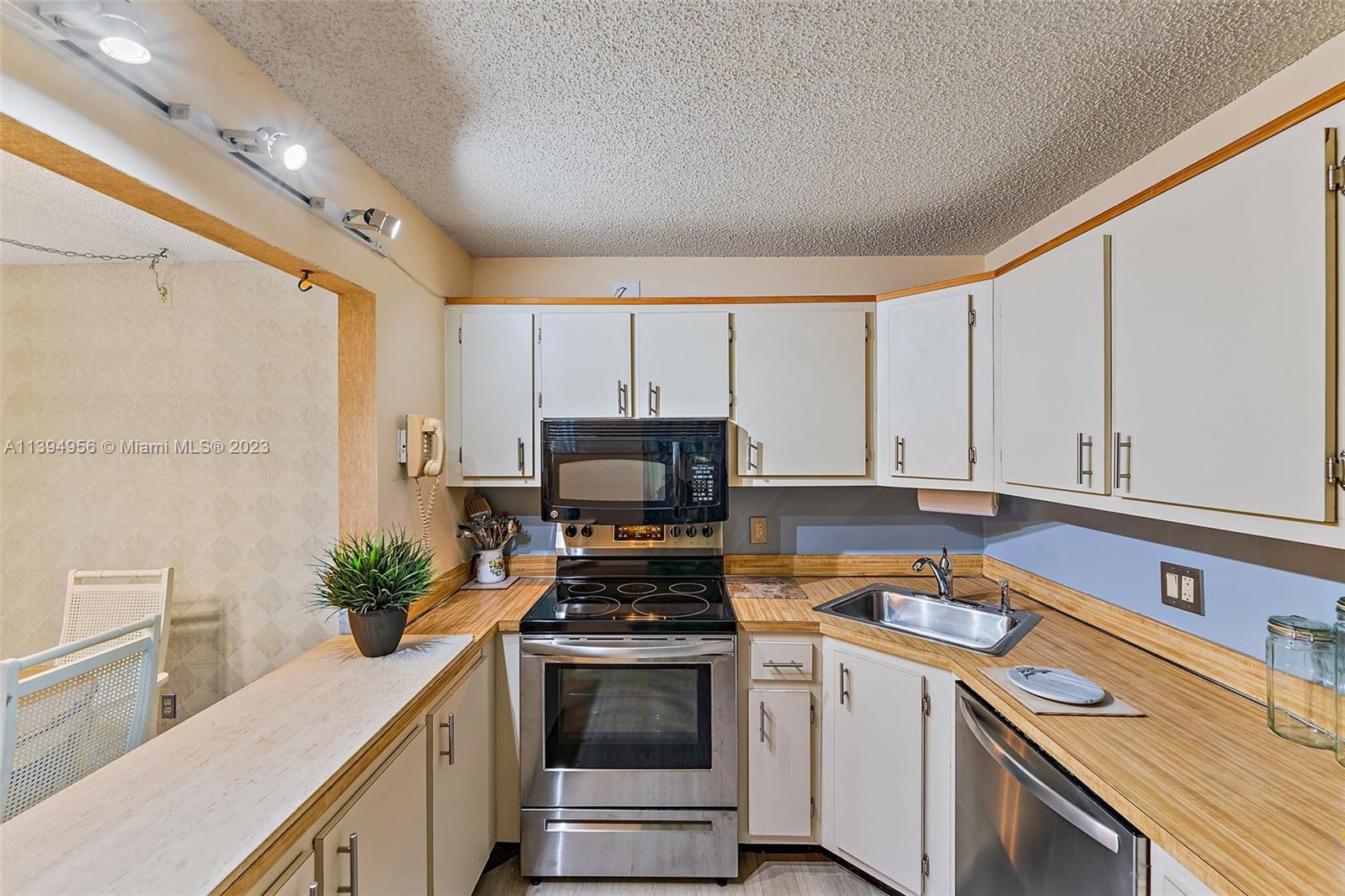 307 Pine Ridge Circle, Unit D2 Greenacres, FL 33463 - Photo 15 of 41 a kitchen with a sink stove and cabinets