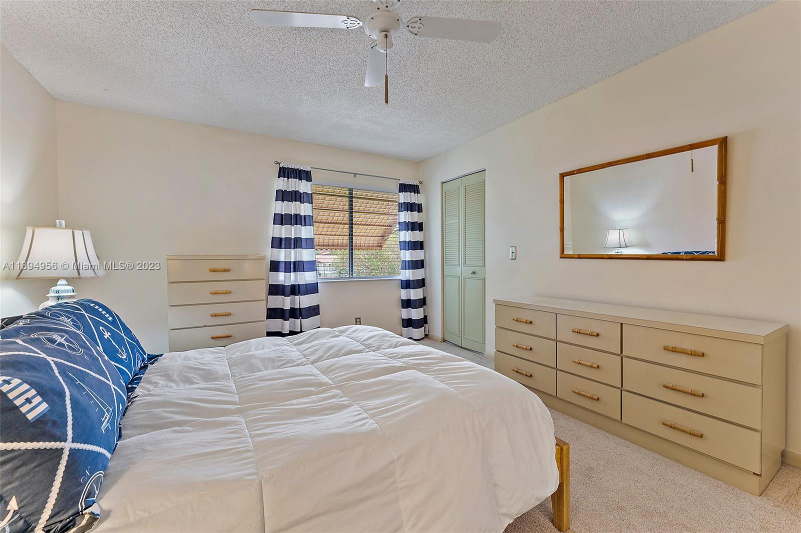 307 Pine Ridge Circle, Unit D2 Greenacres, FL 33463 - Photo 19 of 41 a bedroom with a large bed and a chandelier