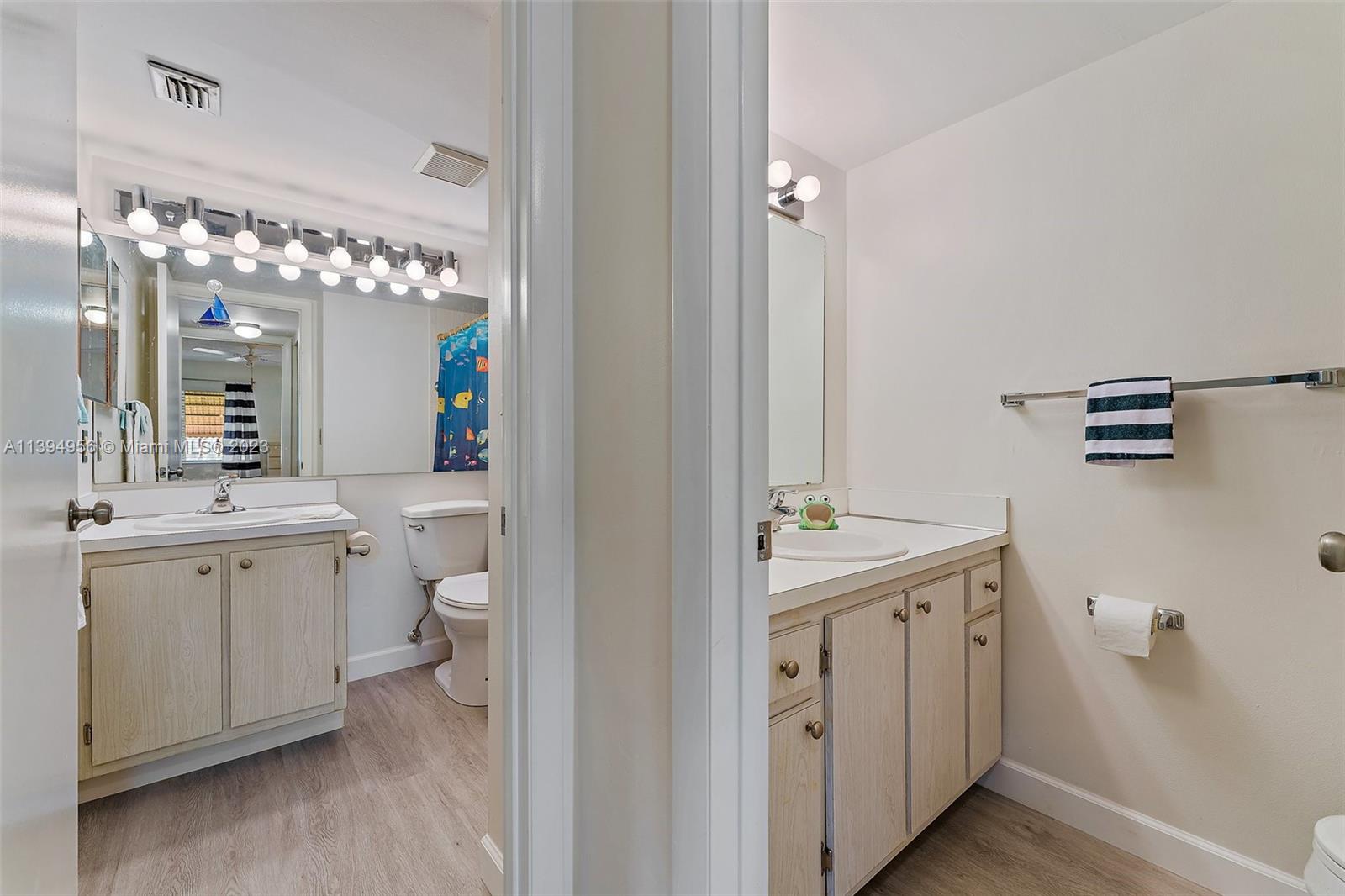 307 Pine Ridge Circle, Unit D2 Greenacres, FL 33463 - Photo 22 of 41 a spacious bathroom with a toilet sink and mirror